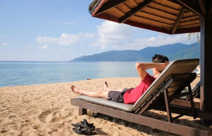 آفتاب گرفتن مرد کنار ساحل 5454341